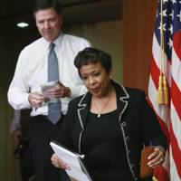 U.S. Attorney General Loretta Lynch and FBI Director James Comey arrive at a media briefing at the Justice Department in Washington Thursday. | REUTERS