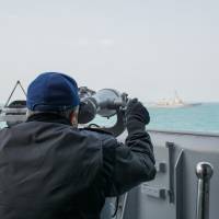 A crew member from the Maritime Self-Defense Force\'s Kurama shoots a line of bearing to the guided-missile destroyer USS Lassen on Feb. 13, when the Lassen was on patrol. | USS GEORGE WASHINGTON (CVN 73)