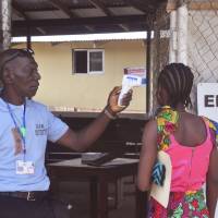A unidentified family member of a 10-year old boy that contracted Ebola has her temperature measured by a health worker before entering the Ebola clinic were the child is being treated on the outskirts of Monrovia, Friday. | AP