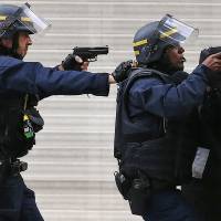 Police draw their weapons in Saint-Denis, one of Paris\' northern suburbs, on Wednesday, days after the Nov. 13 terrorist attacks in the capital. | AP