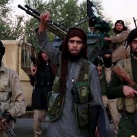 A man identified as \"al-Karar the Iraqi\" raises his fist as he speaks at an undisclosed location in this undated image taken from video released by the Islamic State group on Monday. | REUTERS
