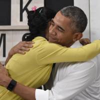 U.S. President Barack Obama gets a hug from a 16-year-old refugee from Myanmar after speaking about the issue during a visit to a refugee center in Kuala Lumpur on Saturday. | AP