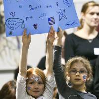 Girls hold up a sign on Friday during a rally at Unitarian Universalist Church in Roanoke, Virginia, after Mayor David Bowers invoked the mass detention of Japanese-Americans during World War II in comments about keeping Syrian refugees out of the region. | AP