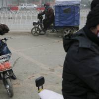 Women wear protective masks on an extremely polluted day in Baoding, China, on Monday. Baoding, located in Hebei province neighboring Beijing, was the most polluted city in China in the first half of 2015, according to the Ministry of Environmental Protection. | REUTERS