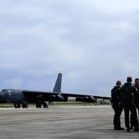 U.S. Air Force personnel cover their ears as a B-52 Stratofortress bomber taxis past during Exercise Cope North in Guam, in this file image from 2011. The U.S. Air Force and Japan\'s Air Self Defense Force conduct Cope North annually at Andersen Air Force Base, Guam, to increase combat readiness. | U.S. AIR FORCE