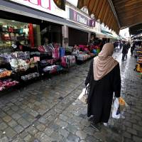 A woman walks Tuesday in the suburb of Molenbeek, after security was tightened in Belgium following the fatal attacks in Paris on Friday. | REUTERS
