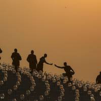 Buddhist monks prepare for an alms offering ceremony at the Wat Phra Dhammakaya temple in Thailand\'s Pathum Thani province, north of Bangkok, in March. | REUTERS