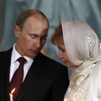 Vladimir Putin, then Russia\'s prime minister, talks with his wife, Lyudmila, during an Orthodox Easter service in the Christ the Savior Cathedral in Moscow on April 23, 2011. | REUTERS