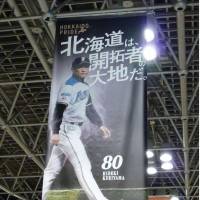 A Hokkaido Nippon-Ham Fighters banner being hung at the New Chitose Airport in Sapporo bears the slogan, \"Hokkaido is the land of pioneers.\" The phrase has caused a stir among the indigenous Ainu people, who see development of Hokkaido by mainland Japanese as a negative event that deprived them of their homeland. | KYODO