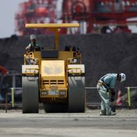 Workers repair a coal loading facility at Onahama port in Iwaki, Fukushima Prefecture. Japan\'s government and industry are backing emerging coal technologies that they say are less damaging to the environment. | BLOOMBERG