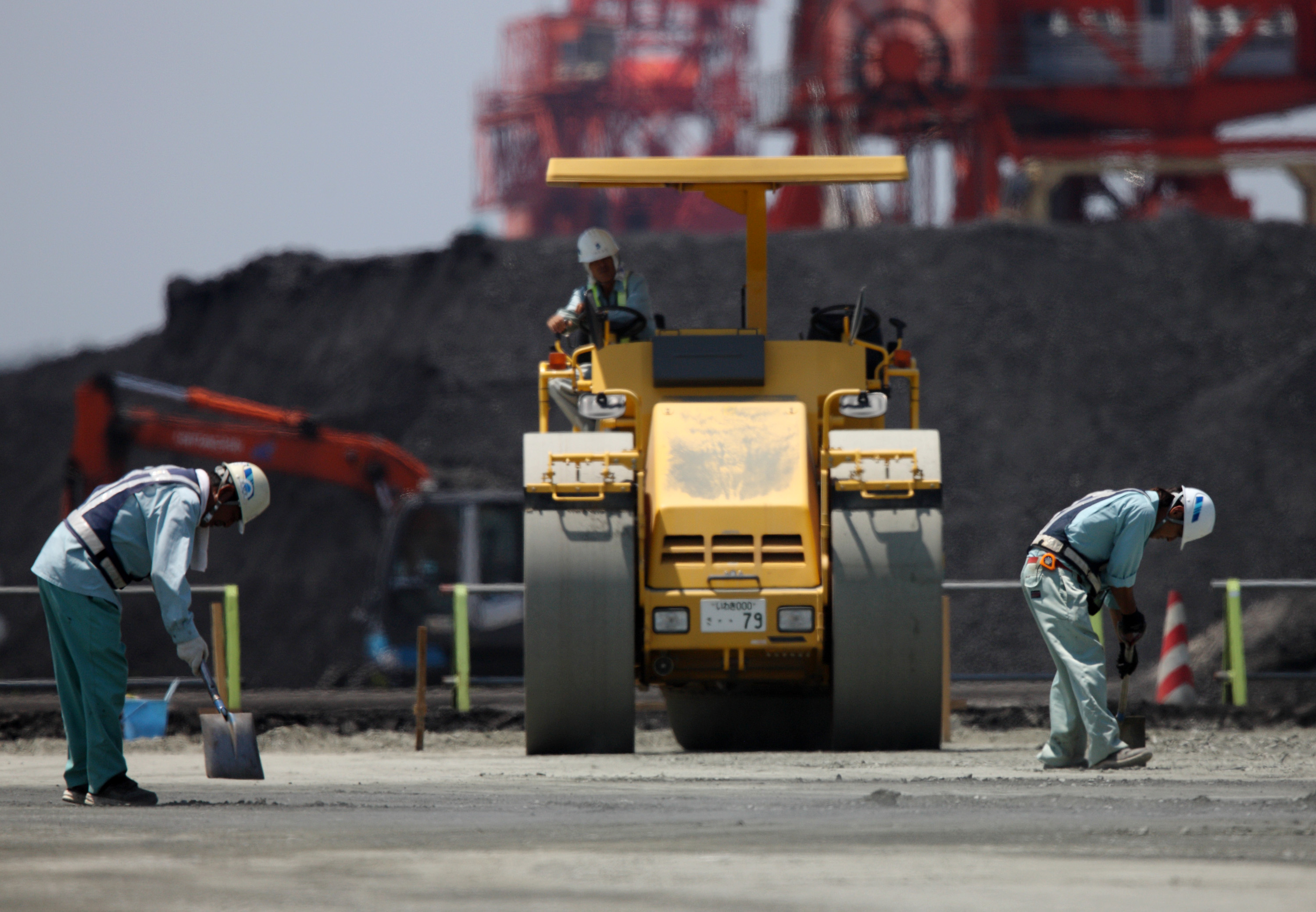 Workers repair a coal loading facility at Onahama port in Iwaki, Fukushima Prefecture. Japan's government and industry are backing emerging coal technologies that they say are less damaging to the environment. | BLOOMBERG