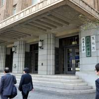 People walk by the education ministry, which houses the Cultural Affairs Agency, on Thursday in Tokyo. | YOSHIAKI MIURA