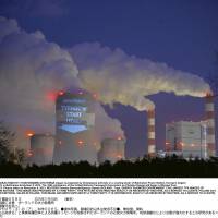 A slogan projected by activists lights up a cooling tower of Belchatow Power Station, Europe\'s largest coal-fired power plant, in Poland in November 2013. | TOMASZ STANCZAK / AGENCJA GAZETA / REUTERS