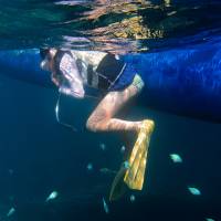 A tourist snorkels in the sea off the island of Ishigaki, Okinawa Prefecture, in June. | BLOOMBERG