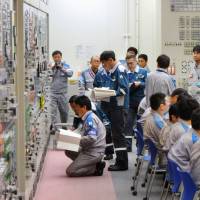 Final checks are conducted for reactor 2 in the central control room of Kyushu Electric Power Co.\'s Sendai nuclear power plant in Satsumasendai, Kagoshima Prefecture, on Tuesday before the unit returned to full commercial operations. | POOL / KYODO