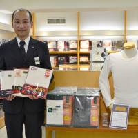 Underwear that use heating functions, like these three products shown off by a staffer at the men\'s clothes section at Takashimaya department store in Tokyo\'s Nihonbashi district, are recommended to help reduce use of heating systems under the \"warm biz\" campaign. | KYODO