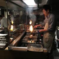 On fire: Duck is prepared at Na Camo Guro\'s grill. | ROBBIE SWINNERTON