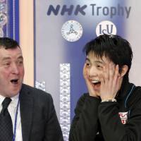 Yuzuru Hanyu (right) and his coach Brian Orser celebrate his winning performance in the men\'s free skate on Saturday at Nagano\'s Big Hat. | REUTERS