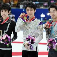 Men\'s singles winner Yuzuru Hanyu  (center) poses with runner-up Jin Boyang of China (left) and third-place finisher Takahito Mura on the podium during the NHK Trophy on Saturday in Nagano. | AFP-JIJI