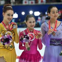 (From left) Runner-up Courtney Hicks of the United States, winner Satoko Miyahara and third-place finisher Mao Asada stand together after the women\'s singles competition at the NHK Trophy on Saturday. | AFP-JIJI