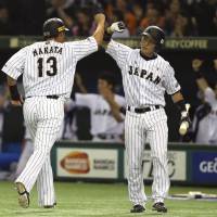 Japan\'s Sho Nakata celebrates with catcher Motohiro Shima after scoring on a single by left fielder Ryosuke Hirata during the fourth inning of their Premier 12 semifinal game against South Korea on Thursday at Tokyo Dome. | AP
