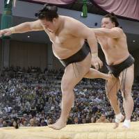 Yokozuna Harumafuji bulldozes Goeido out of the raised ring on Thursday at the Fukuoka Grand Sumo Tournament. | KYODO