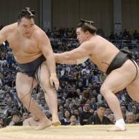 Harumafuji (right) shoves Kakuryu out of the ring at the Kyushu Grand Sumo Tournament on Saturday. | KYODO