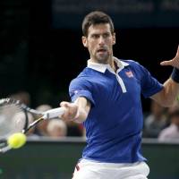 Novak Djokovic hits a return against Andy Murray during the Paris Masters final on Sunday. Djokovic won 6-2, 6-4. | REUTERS