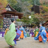 Local residents dressed as aristocrats play kemari at Tanzan Shrine in Sakurai, Nara Prefecture, during a festival Tuesday. The annual event celebrates the noncompetitive game, which was once played by nobles. | KYODO