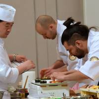 Sushi chefs William Santos (right) from Portugal and Kasper Krajewski (center) from Poland prepare food in the final stage of the Global Sushi Challenge 2015 competition on Wednesday at the Tokyo Marriott Hotel in the capital\'s Shinagawa district. Jun Jibiki from Japan was named the winner, beating 13 rivals at the finals. \"Washoku\" certification: Page 6 | SATOKO KAWASAKI