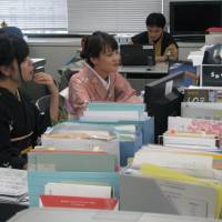 Officials at the Ministry of Economy, Trade and Industry in central Tokyo work in kimono on Monday, the day after \"Kimono Day,\" which was established by the kimono industry to help promote the traditional garment. | KYODO