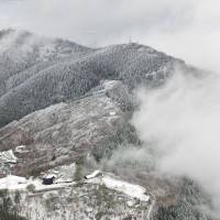 Mount Kongo, which straddles the prefectures of Osaka and Nara, receives its first dusting of snow on Friday, five days earlier than last year. Observers in the nearby village of Chihaya Akasaka reported 1 cm of snow near the summit. They said plunging temperatures reflect the onset of winter atmospheric pressures. | KYODO