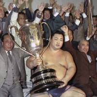  Yokozuna Kitanoumi, who went on to become chairman of the Japan Sumo Association, holds a trophy in this 1984 file photo | KYODO