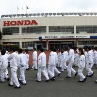 Workers are seen at Honda Motor Co.\'s plant in Ozu, Kumamoto Prefecture, in this 2014 file photo. The automaker plans to lift the retirement age by five years to 65. | BLOOMBERG