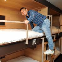 Yosuke Irie, chief executive officer of Emblem Japan Co., shows off a room at the Emblem Hostel in Tokyo\'s Adachi Ward on Dec. 16. | YOSHIAKI MIURA
