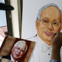 An artist paints a picture of Malaysian Prime Minister Najib Razak in Kuala Lumpur on Monday. | REUTERS