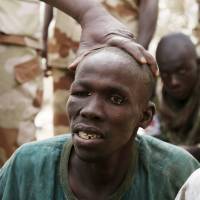 A man the Chadian military said they took prisoner for belonging to insurgent group Boko Haram is seen in Gambaru, Nigeria, in February. The Chadian military nicknamed the man \"the Butcher.\" Cameroon forces said Wednesday they captured a Boko Haram chief and freed 900 captives. | REUTERS