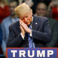 U.S. Republican presidential candidate Donald Trump gestures as if he is sleeping while talking about his opponent Jeb Bush during a Trump for President campaign rally in Raleigh, North Carolina on Friday. | REUTERS