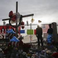 People pay respects at a makeshift memorial honoring the victims of Wednesday\'s shooting rampage that killed 14 people, Saturday in San Bernardino, California. | AP