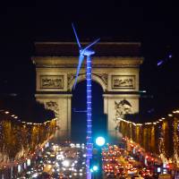 A power-generating windmill turbine is seen on the Champs Elysees avenue with the Arc de Triomphe in background as part of the COP21, United Nations Climate Change Conference, in Paris Wednesday. | AP