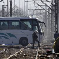 A bus carrying migrants heads south from the Idomeni border crossing in northern Greece by the border with Macedonia, photographed from the Macedonian side of the border, near the town of Gevgelija, on Wednesday. Escorted by the police, the buses with migrants are expected later Wednesday in Athens, where authorities have set up shelters and will encourage the migrants to make asylum applications in Greece. | AP