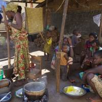 People prepare food at a homestead in Conakry Tuesday. Guinea has been declared free from transmission of Ebola, the World Health Organization said Tuesday, marking a milestone for the West African country where the original Ebola chain of transmission began two years ago leading to the largest epidemic in history. | AP