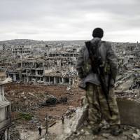 A Kurdish marksman looks out over Kobane on Jan. 30 after Kurdish forces recaptured the Syrian town from jihadis. | AFP-JIJI