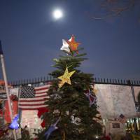 A Christmas tree stands in a makeshift memorial near the Inland Regional Center in San Bernardino, California, Monday. | AFP-JIJI