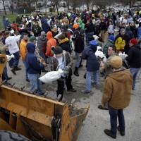 Volunteers form a human chain as they help load sandbags Tuesday in St. Louis. | AP