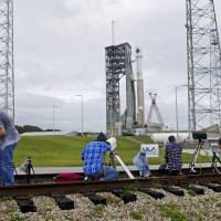 A United Launch Alliance Atlas V rocket stands ready for a second launch attempt at launch complex 41at the Cape Canaveral Air Force Station as photographers adjust their remote cameras Friday. | AP