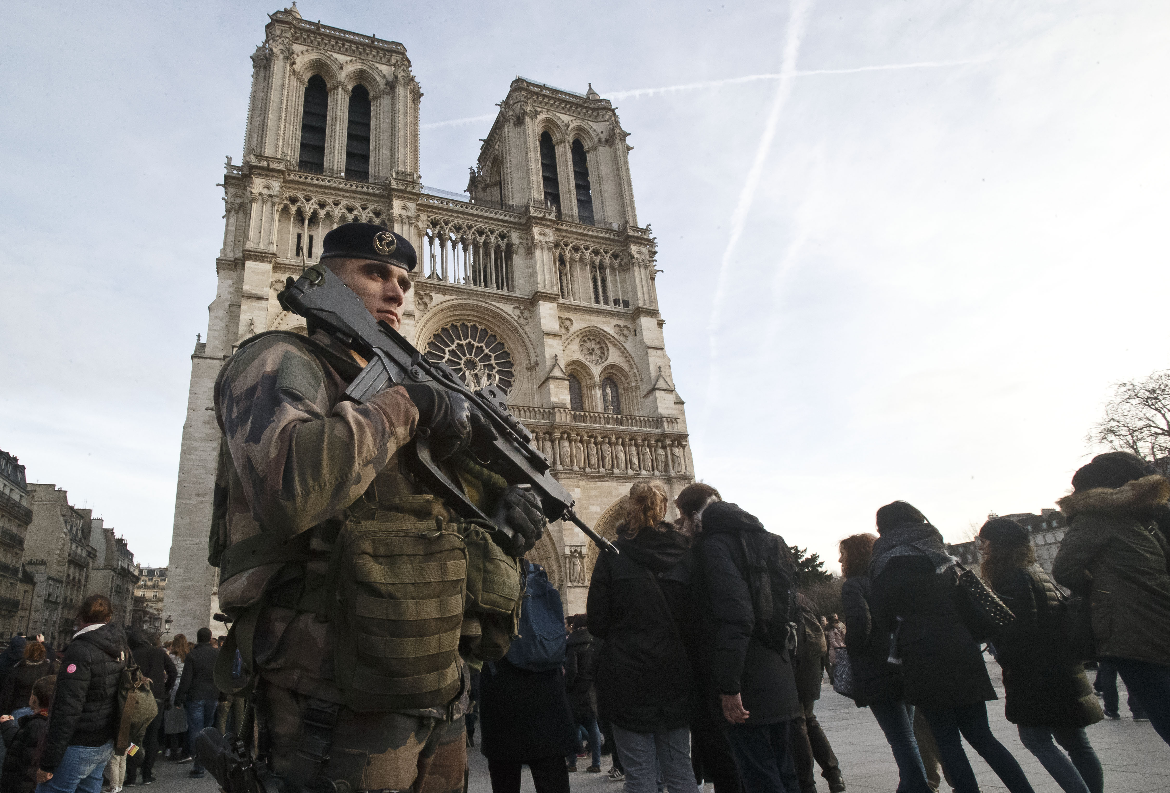 A soldier patrols at the Notre Dame cathedral in Paris, Wednesday. France's defense minister has visited troops on duty ahead of unusually tense New Year's Eve celebrations in Paris after November attacks that left 130 dead and hundreds injured. | AP
