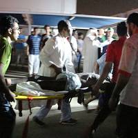 Medics evacuate the body of a victim from inside the Jazan General Hospital after a blaze broke out in the intensive care unit and the maternity department on Thursday in Saudi Arabia\'s southern Jizan province. | AFP-JIJI