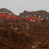 Rescue workers conduct a search on Wednesday, three days after an industrial estate was hit by a landslide in Shenzhen, China. | REUTERS