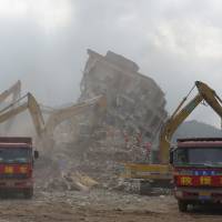 Workers clear debris on Wednesday following the previous Sunday\'s landslide at an industrial park on in Shenzhen, China. | REUTERS